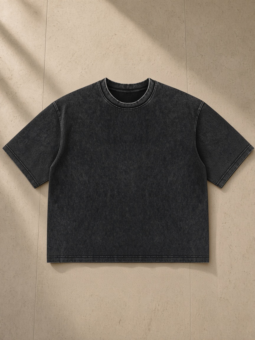 Heavyweight Mineral Wash Boxy T-Shirt in Black, laid flat on pale limestone