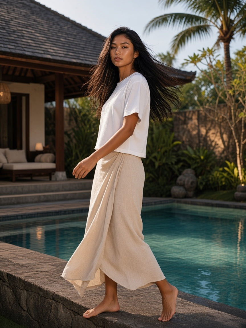 Woman in the Heavyweight Mineral Wash Boxy T-Shirt in White by a villa pool in Bali in the morning