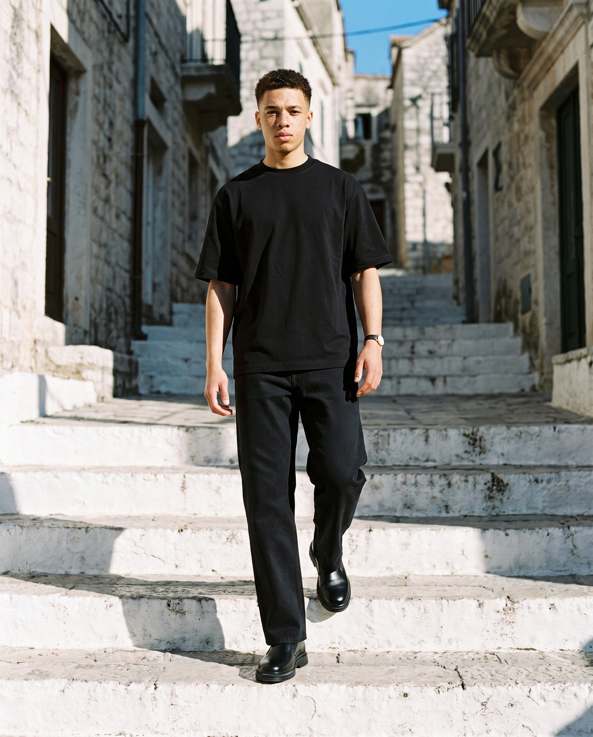 Man wearing the Marcel Afters Heavyweight Straight-Leg Trousers in Black, full-length editorial photograph