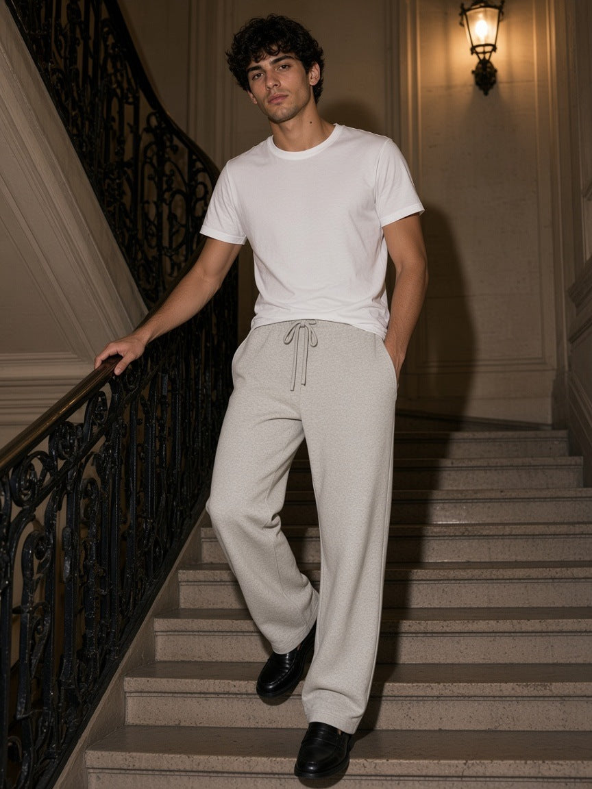 Man in the Heavyweight Sweatpants in Oat Gray coming down a Haussmann staircase in Paris at night