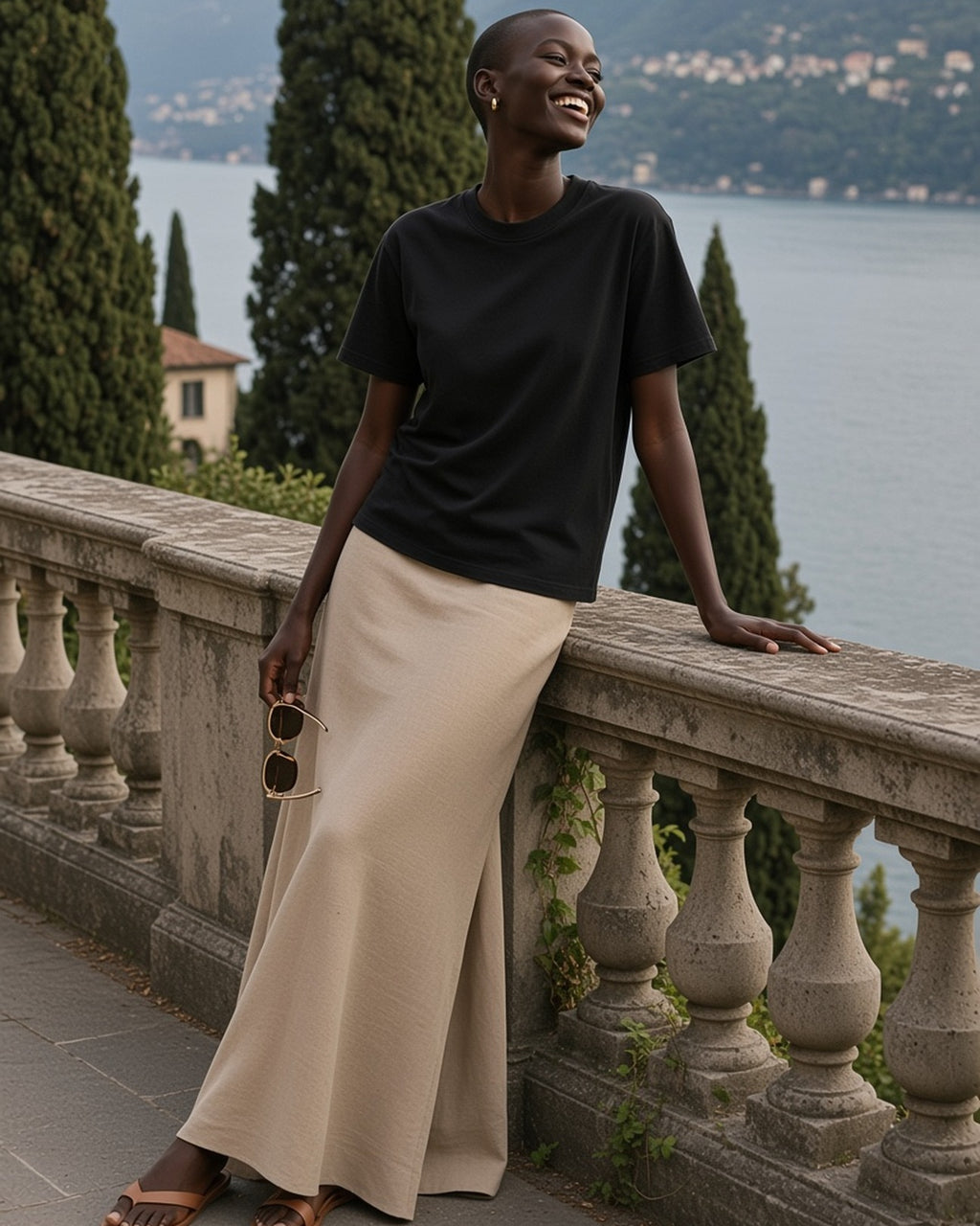 Woman in the Heavyweight Vintage Washed Frayed T-Shirt in Black, laughing on a villa terrace on Lake Como