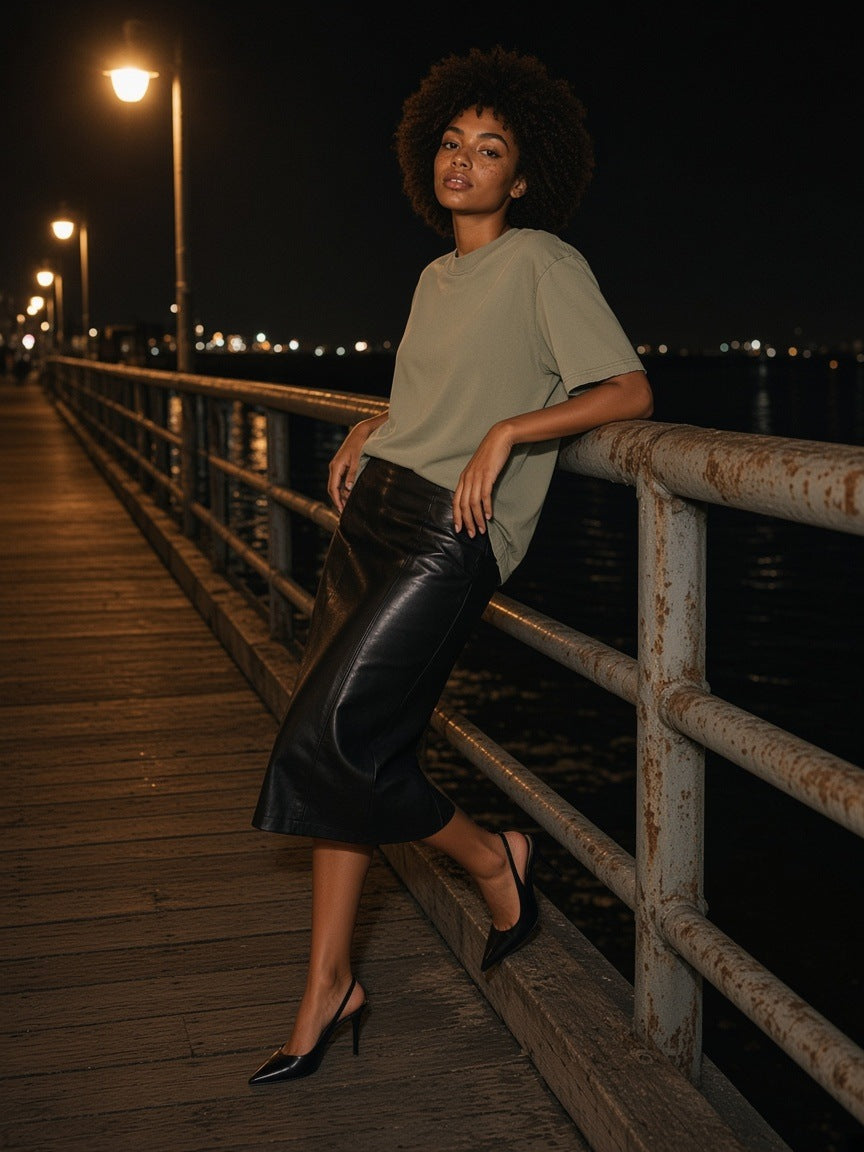Woman in the Heavyweight Vintage Washed Frayed T-Shirt in Gray Green leaning on a pier railing at night