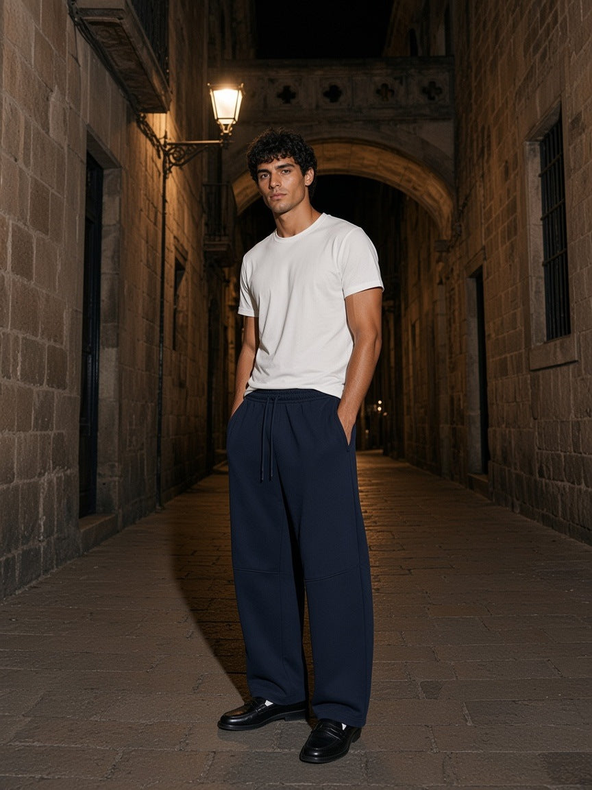 Marcel Afters Heavyweight Wide Leg Panel Sweatpants in Navy Blue, worn by a man, alley