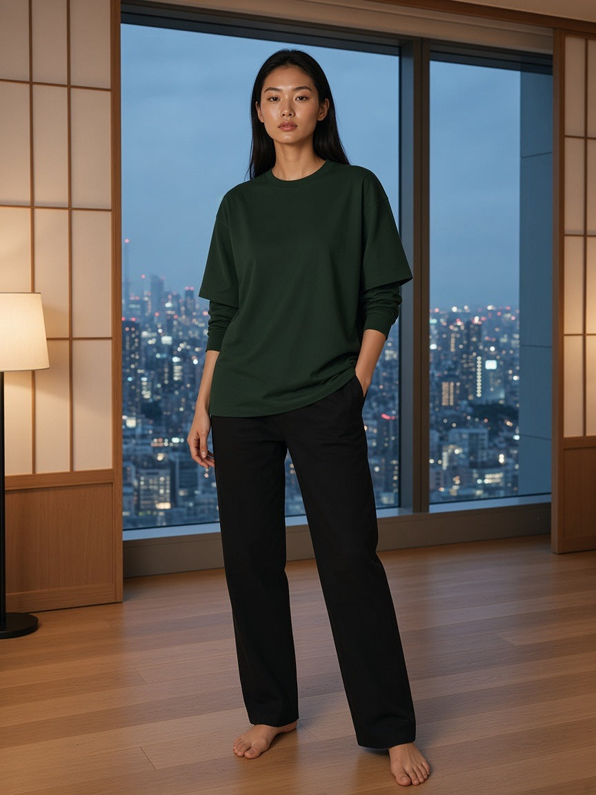 Marcel Afters Layered Oversized T-Shirt in Dark Green, worn by a woman, standing barefoot in a paper-screen room above the city