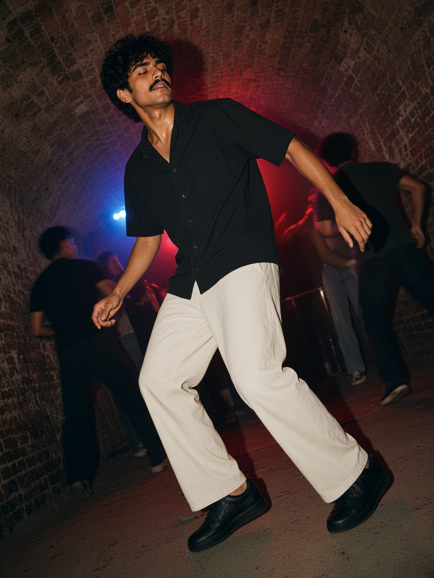Part of the look Dark Room: man in a black lightweight short-sleeve shirt and pale khaki straight-leg pants