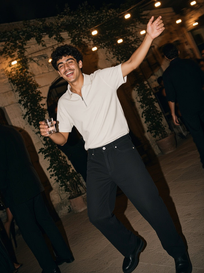 Part of the look Half Past Three: man in a pale khaki half-zip polo and black straight-leg pants