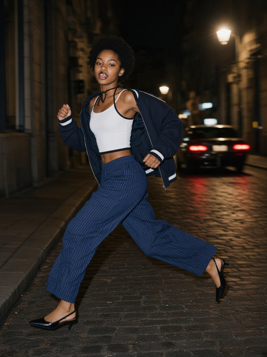 Part of the look Last Cab: woman in a white halter, navy striped pleated pants and a navy piped zip bomber