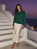 Marcel Afters Loose Crewneck Sweatshirt in Dark Green, worn by a woman, on a rooftop at dusk