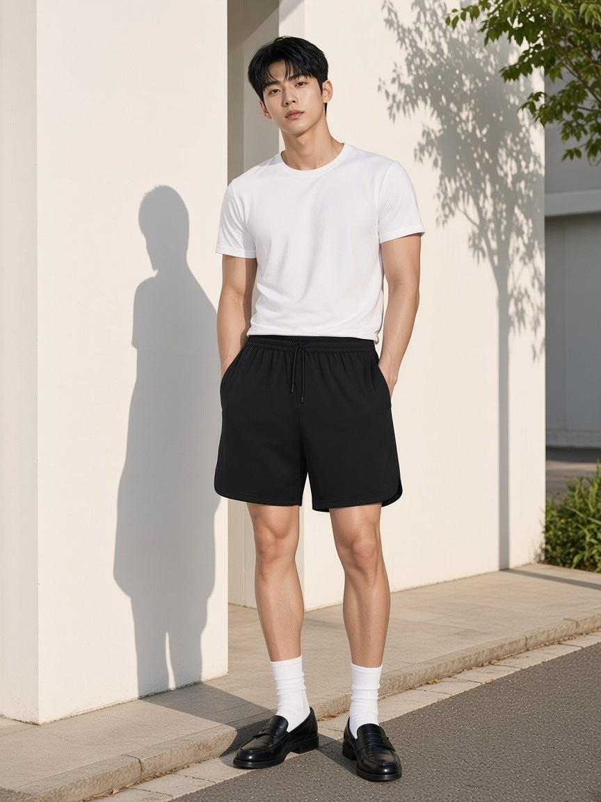 Marcel Afters Mesh-Lined Quick-Dry Performance Shorts in Black, worn by a man, outdoors