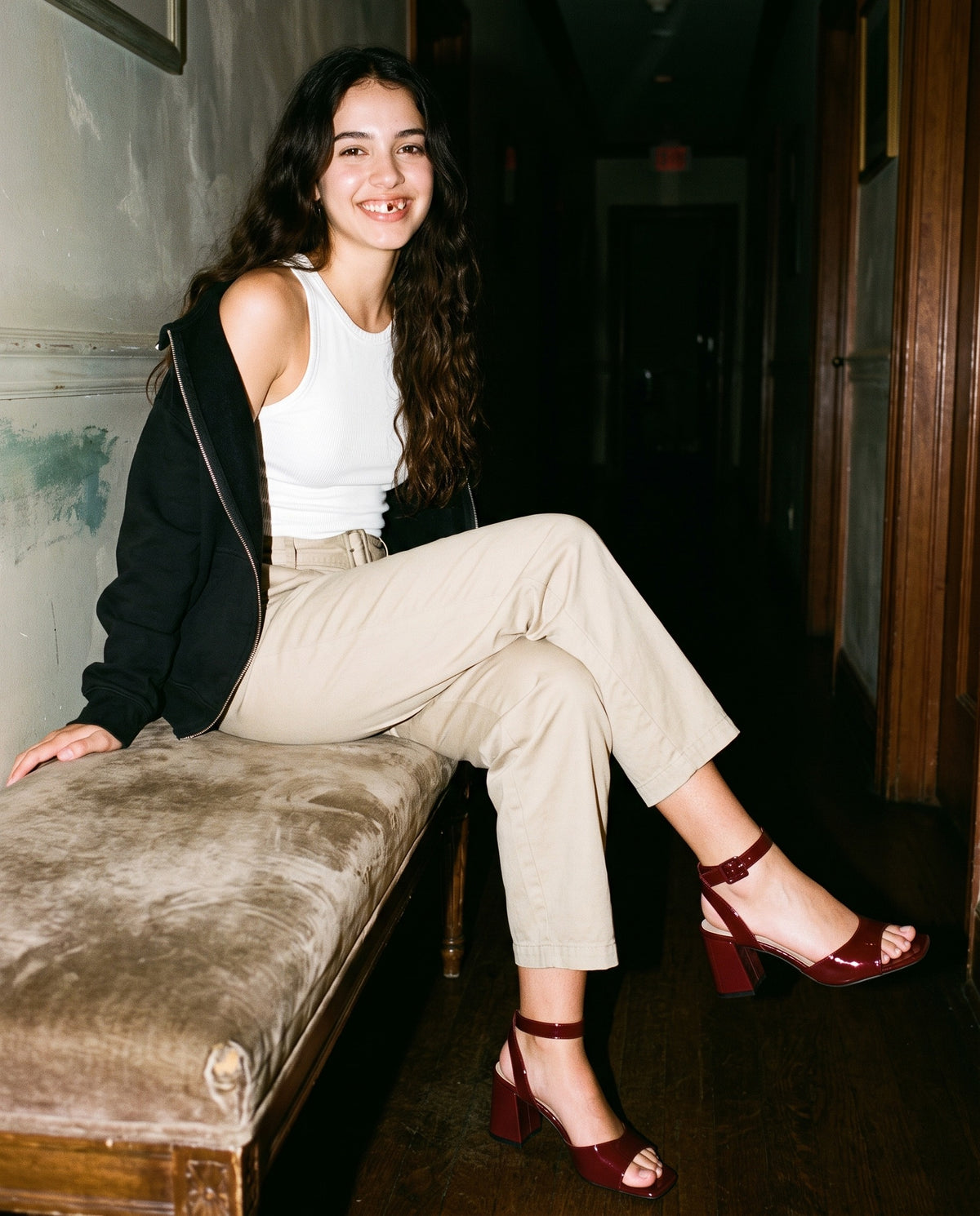 Woman wearing The One More Sandal with the Snow Washed Tank Top in White, Belted Barrel-leg Chino Pants in Beige, Quarter-Zip Pullover Sweatshirt in Black. Past Midnight, Autumn–Winter 2026 campaign
