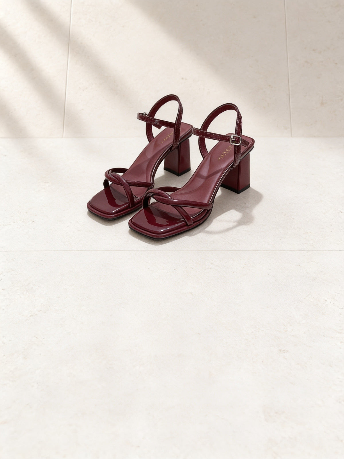 The One More Sandal in Wine, pair on pale limestone