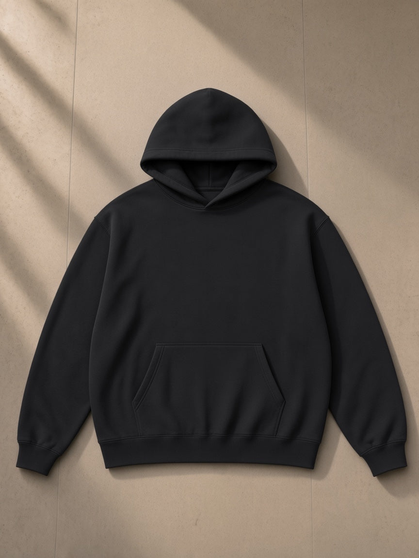 Unisex oversize heavyweight fleece hoodie in Black Beauty, laid flat on pale limestone, front view
