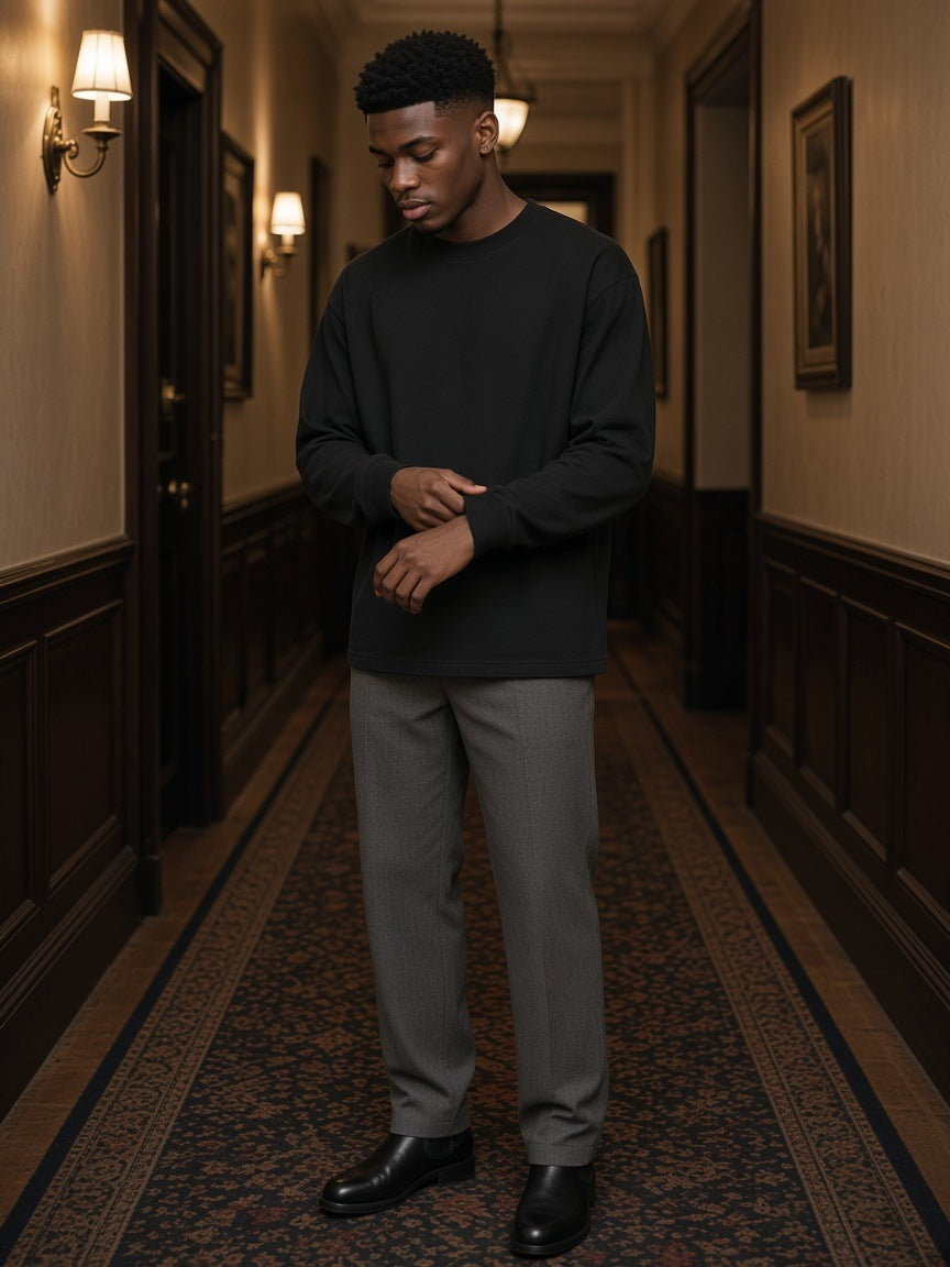 Marcel Afters Oversized Long Sleeve T-Shirt in Black, worn by a man, hallway
