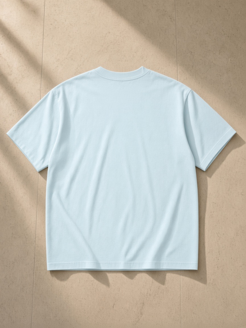 Oversized T-Shirt in Sky Blue, laid flat on pale limestone, back.