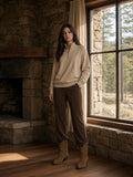Marcel Afters Quarter-Zip Pullover Sweatshirt in Beige, worn by a woman, stone fireplace