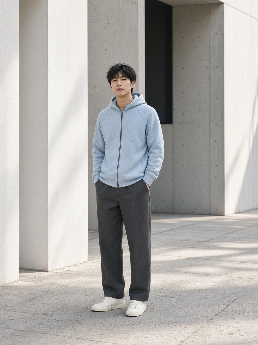 Marcel Afters Raglan Full Zip Hoodie in Light Blue, worn by a man, standing among concrete columns in grey trousers