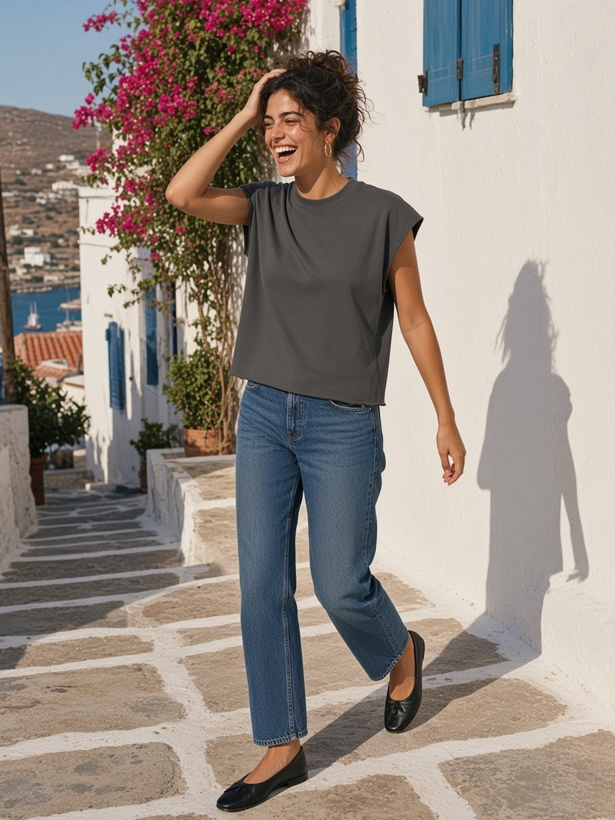 Woman in the Raw Edge Boxy Non-Shrink T-Shirt in Dark Gray laughing on a whitewashed stepped lane on Hydra in the morning