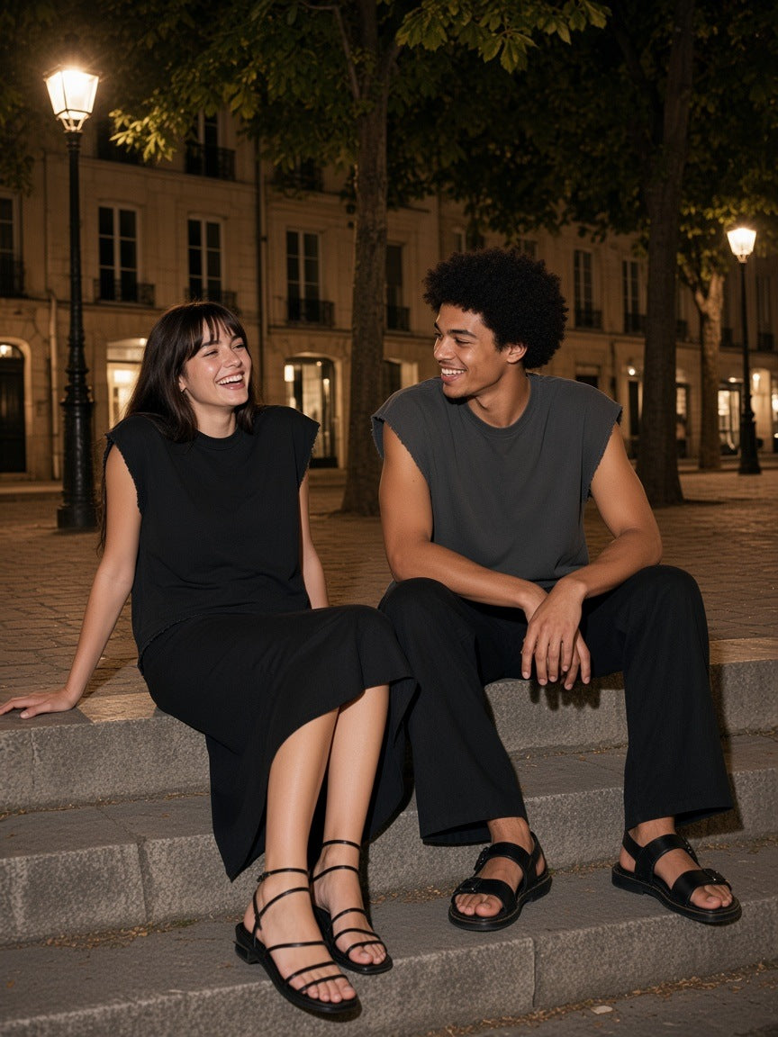 Two people in the Raw Edge Boxy Non-Shrink T-Shirt in Black and Dark Gray on the steps of Place Dauphine in Paris at night