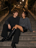 Marcel Afters Raw Edge Crewneck Sweatshirt in Washed Gray, worn by a man and a woman, sitting together on lamp-lit stone steps at night