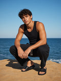 Marcel Afters Relaxed Drawstring Three-quarter Sweatpants in Black, worn by a man, beach