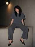 Woman in the Snow Wash Raw-Hem Boxy T-shirt in Washed Cement Gray seated on a ledge at a tunnel exit in London at night
