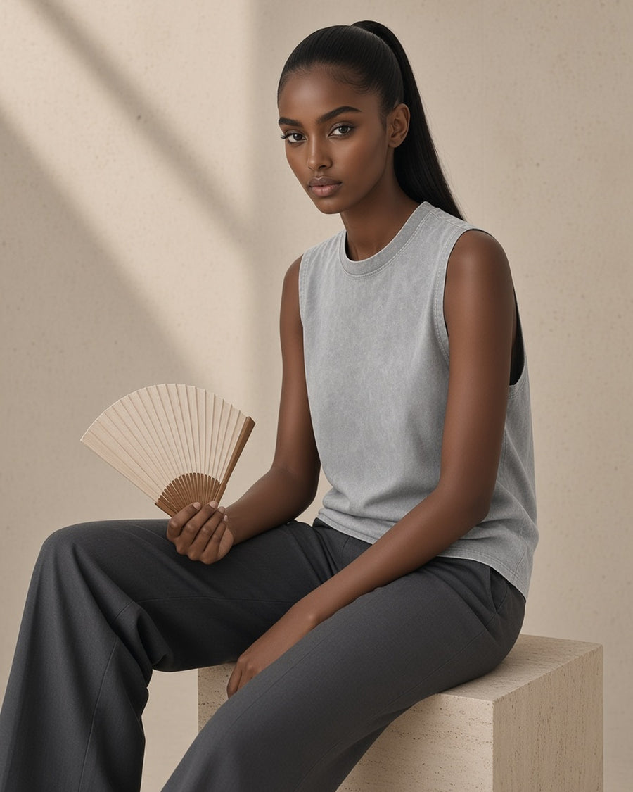 Woman in the Snow Washed Frayed Hem Tank Top in Light Gray, with a paper fan in a limestone studio
