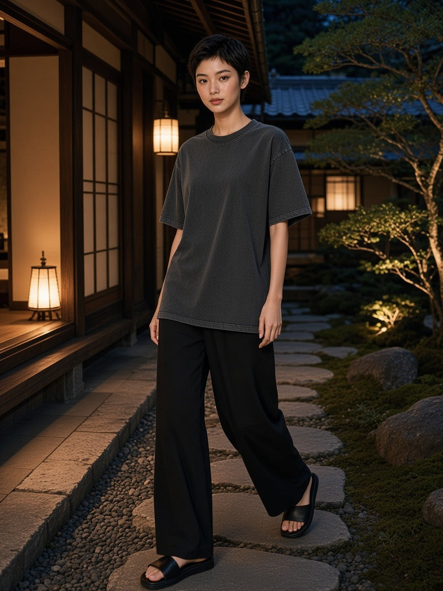 Woman in the Snow Washed Heavyweight Oversize T-Shirt in Gray walking a ryokan garden path in Kyoto at night