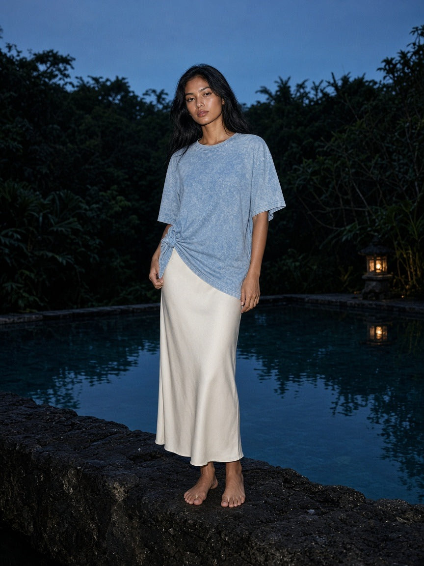 Marcel Afters Snow Washed Oversized Cotton T-Shirt in Blue, worn by a woman, poolside