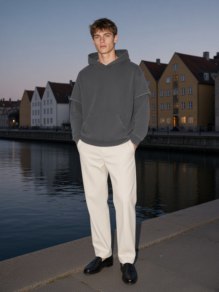 Marcel Afters Snow Washed Raw Edge Double Layered Hoodie in Dark Gray, worn by a man, by a canal