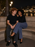 Marcel Afters Snow Washed Straight Leg Pants in Blue, worn by a man and a woman, laughing together on stone steps at night by the river