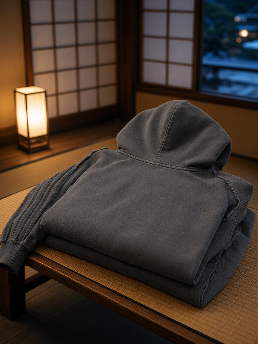 Marcel Afters Snow Washed Tape Raw Edge Zip Hoodie in Dark Gray, laid flat, wooden floor