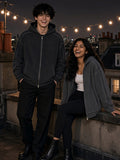 Two people in the Snow Washed Tape Raw Edge Zip Hoodie in Black and Dark Gray on a London rooftop at night
