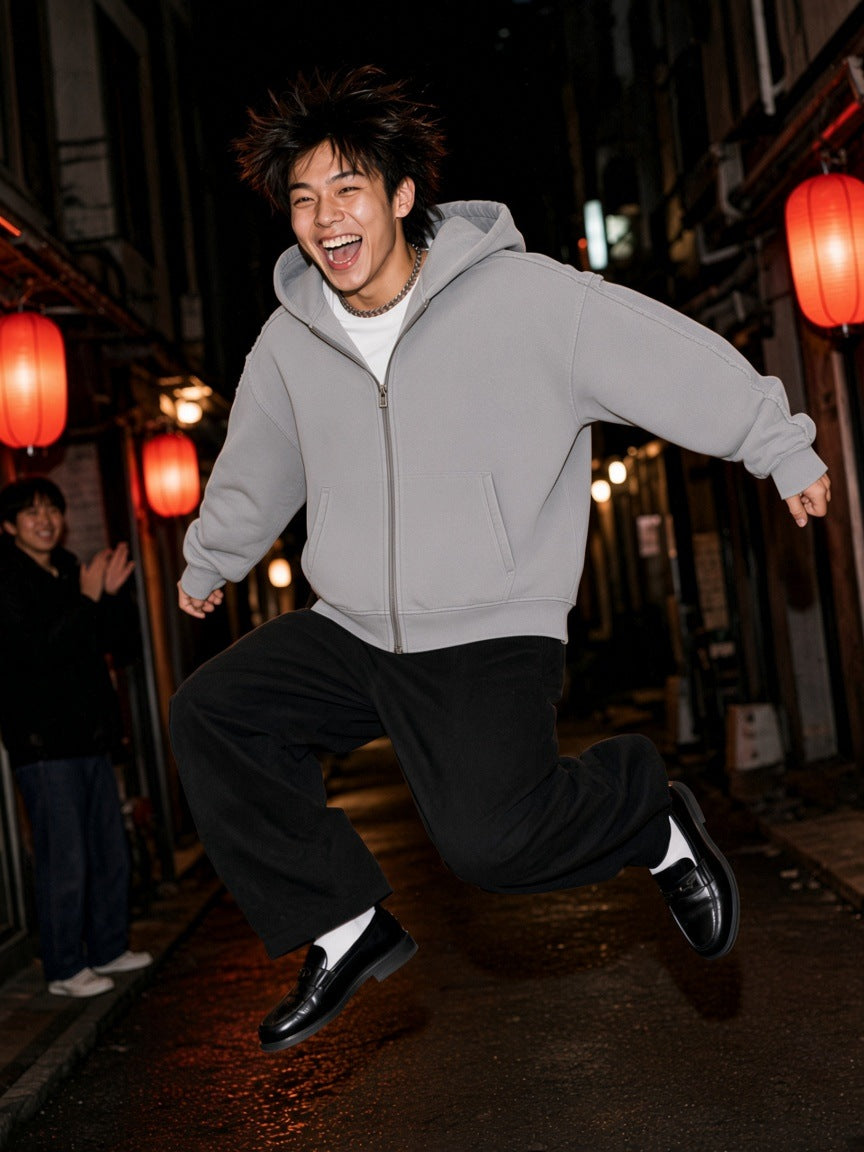 Man in the Snow Washed Tape Raw Edge Zip Hoodie in Light Gray, jumping in an Osaka lantern alley at 1am