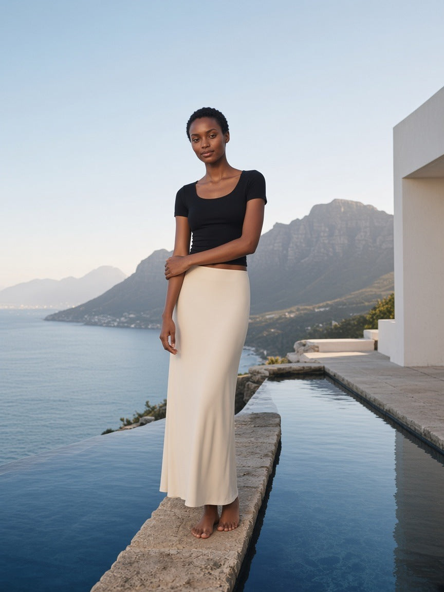 Woman in the Women's Solid Color Slim Crop T-Shirt in Black at a clifftop infinity pool in Cape Town in the morning