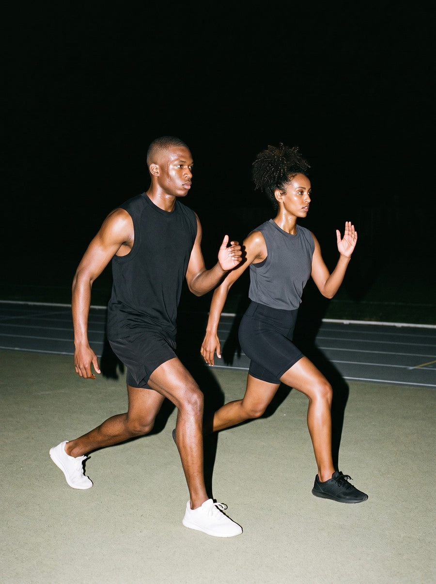 Two people wearing the Sorona Quick-Dry Cooling Tank Top in Dark Gray and Black, full-length model photo