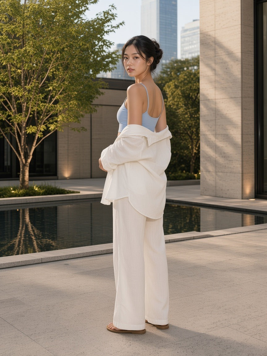 Woman in the Spaghetti Strap Yoga Sports Bra in Haze Blue in a travertine hotel courtyard in Tokyo in the morning