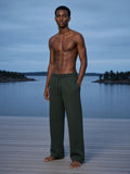 Marcel Afters Straight Leg Sweatpants in Blackish Green, worn by a man, on a dock