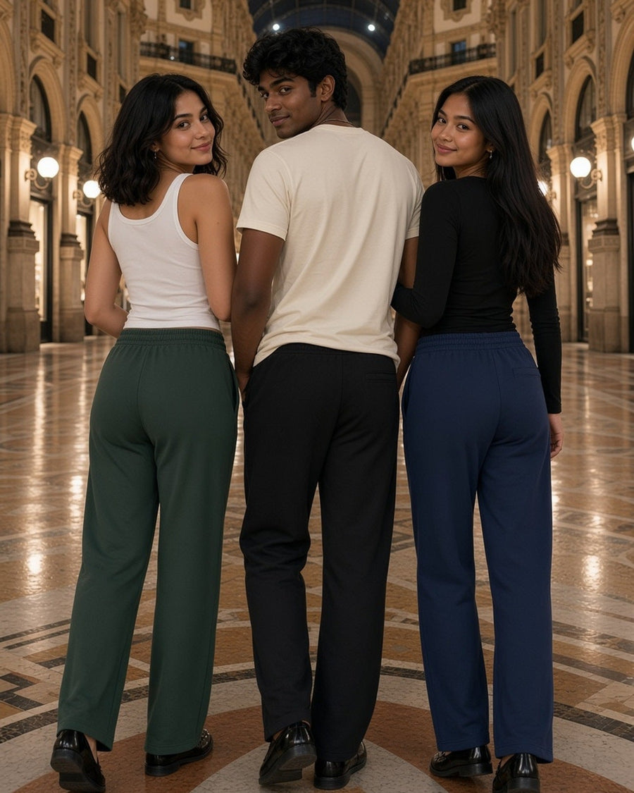 Three people in Blackish Green, Black and Navy Blue straight leg sweatpants, seen from behind in an arcade