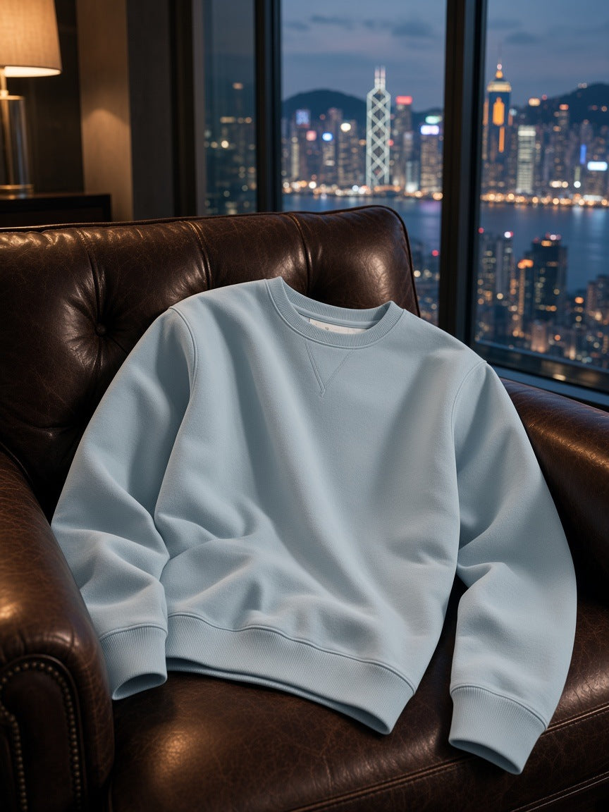 Marcel Afters Streetwear Cotton Pullover in Ice Water, laid flat, dark leather armchair