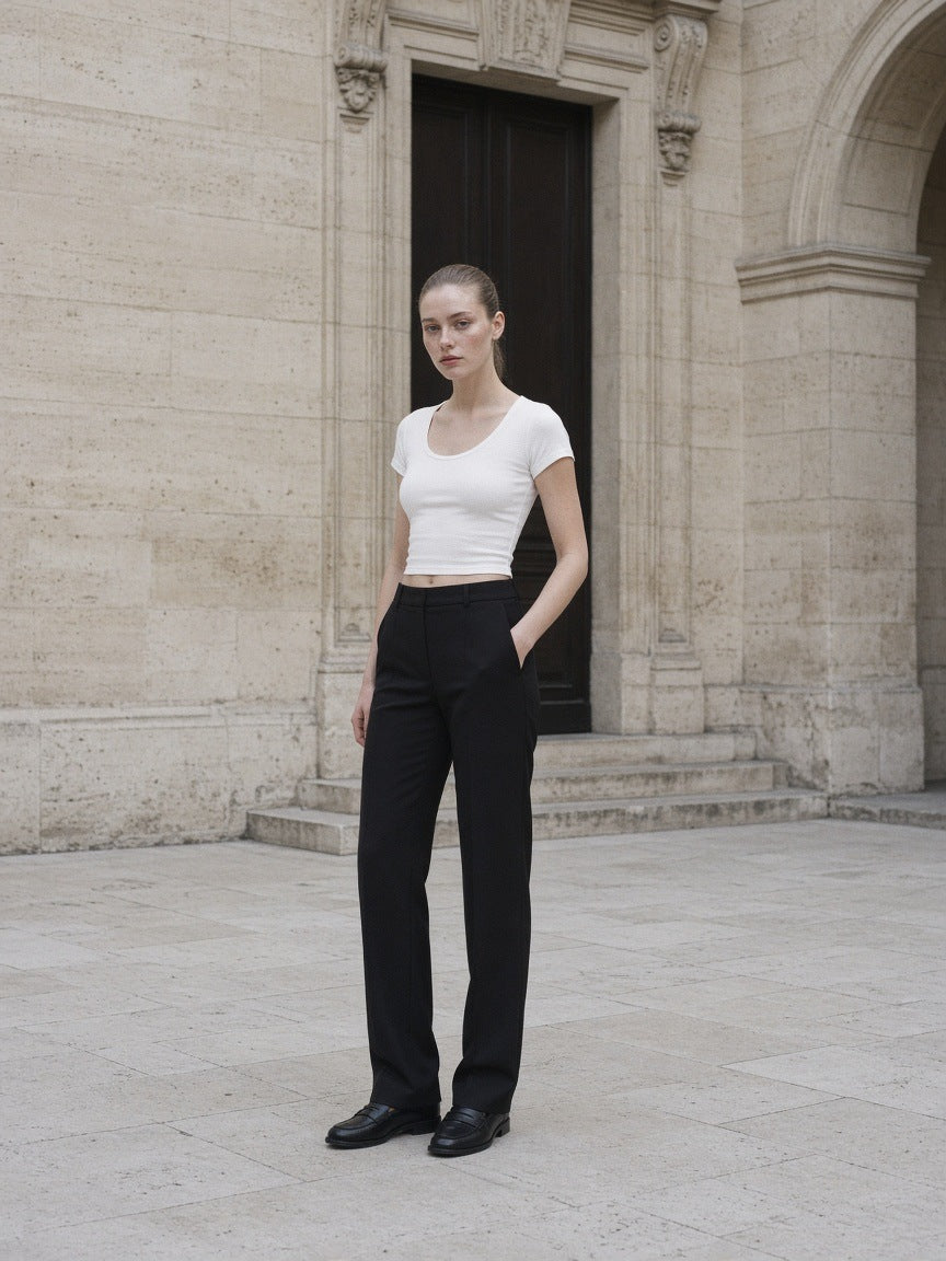 Woman in the Women's Tencel Baby T-Shirt in White against pale limestone in Paris at dawn