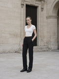 Woman in the Women's Tencel Baby T-Shirt in White against pale limestone in Paris at dawn