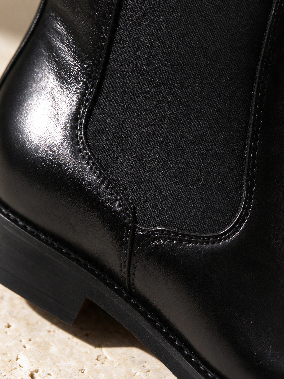 The After Hours Chelsea Boot in black, detail shot: leather, stitching, sole or hardware