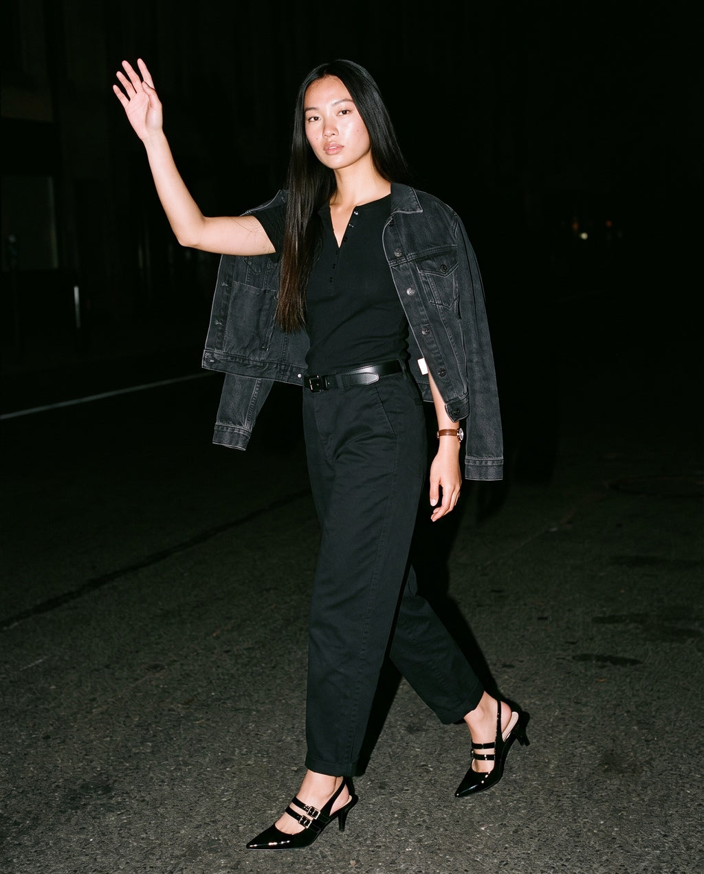The After Six Slingback in black, worn on model, walking at night, hard flash