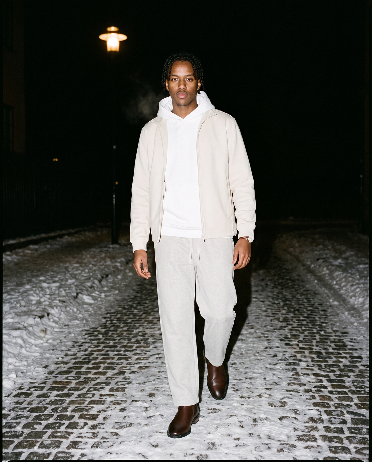 Man wearing the The Last Train Chelsea Boot with the Essential Heavyweight Drop-Shoulder Hoodie in White, Waffle Barrel Leg Pants in Oat Gray, Stand Collar Jacket in Beige. Cold City, Autumn–Winter 2026 campaign