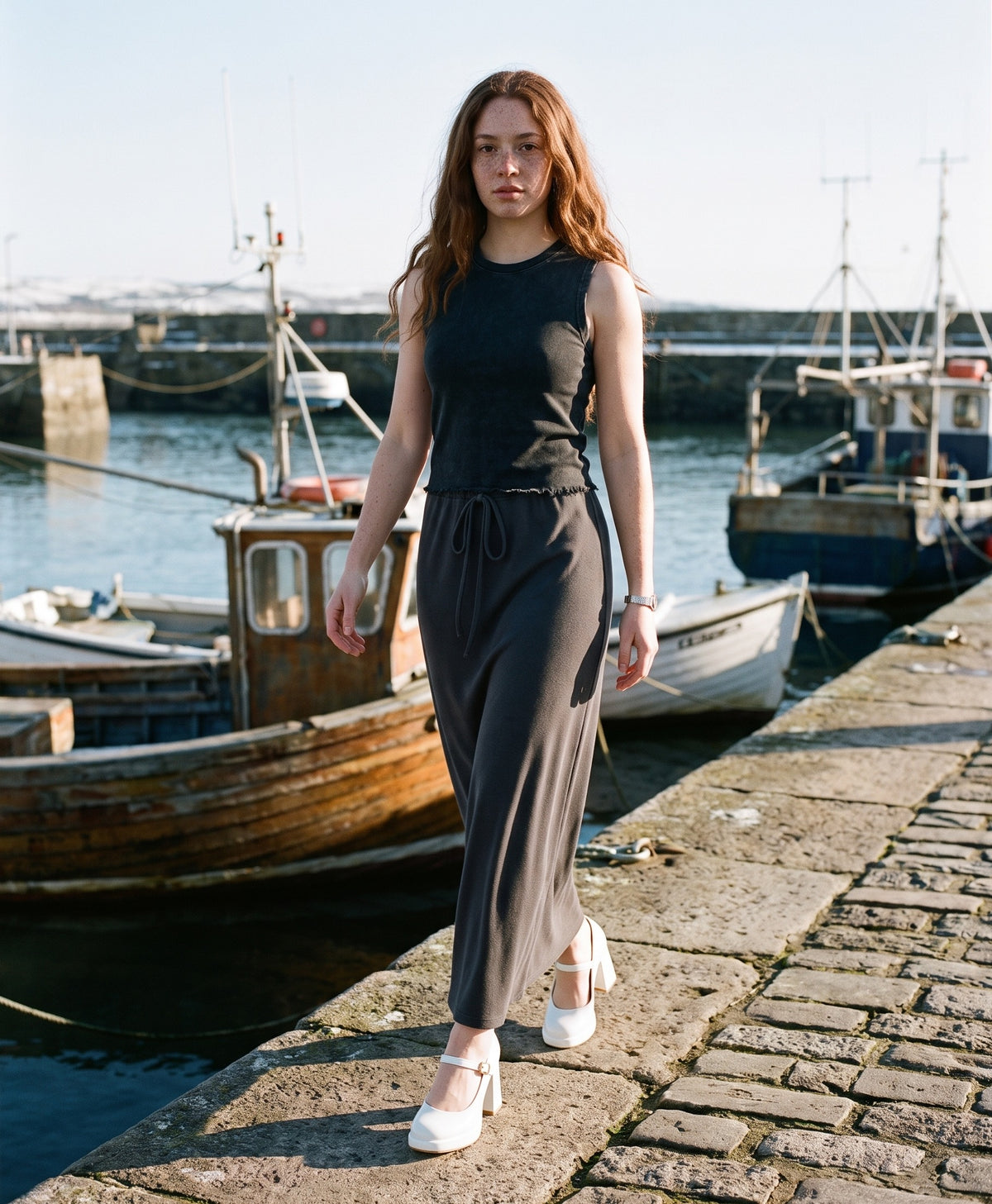 Woman wearing The Lobby Date Mary Jane with the Snow Washed Frayed Hem Tank Top in Black, Dyed Washed Drawstring Maxi Skirt in Dark Gray. Travel Light, Autumn–Winter 2026 campaign