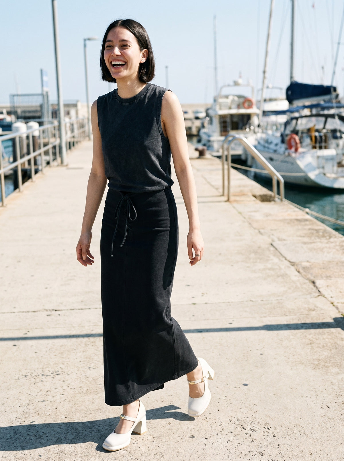 Woman wearing The Lobby Date Mary Jane in White with washed black ankle-length drawstring maxi skirt and a black tank top, flash photograph
