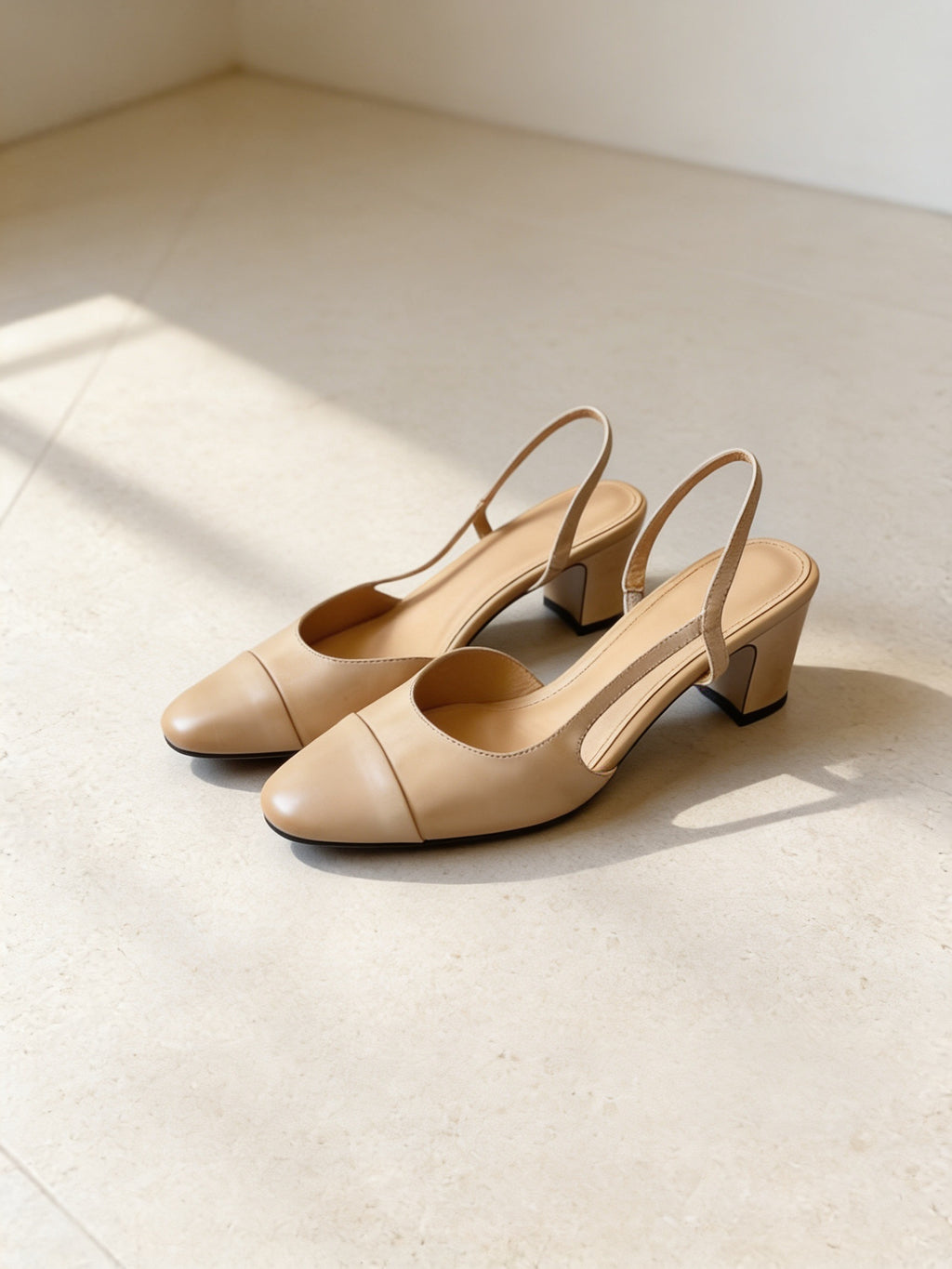 The Long Weekend Slingback in Almond, pair on pale limestone