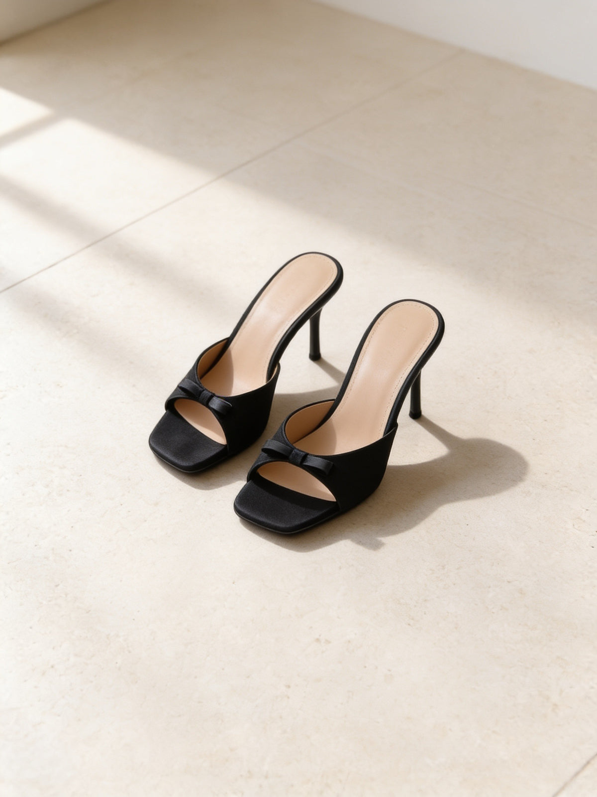 The Nightingale Mule in Black, pair on pale limestone