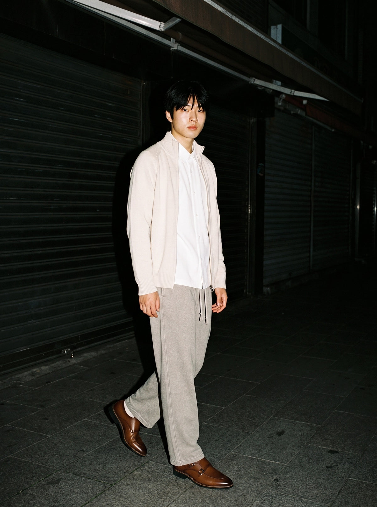 Man wearing The Second Bottle Monk with the Boxy Short Sleeve Shirt in White, Snow Washed Straight Leg Pants in Stone Gray, Heavyweight Collared Quarter-Zip in Beige. After Dark, Autumn–Winter 2026 campaign