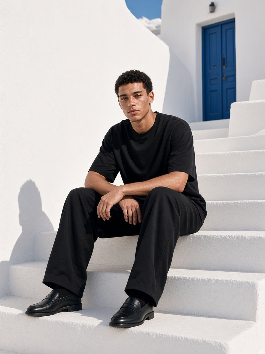 Marcel Afters Boxy Coolmax T-Shirt in Black, worn by a man, white stairs